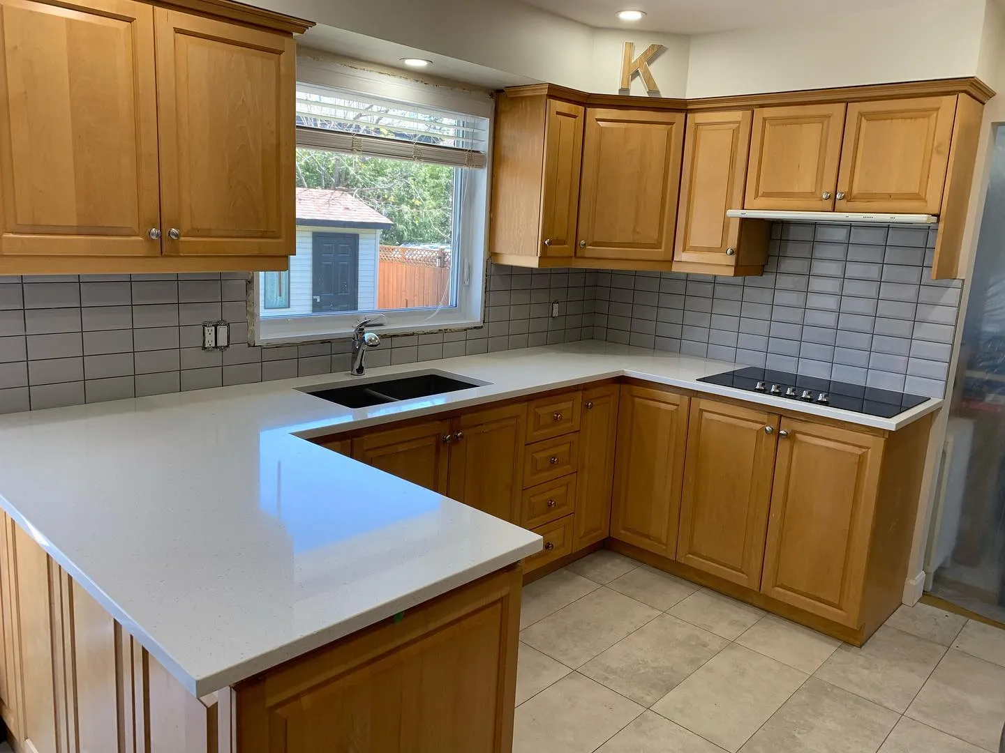 Renovated kitchen with quartz countertops and subway tile backsplash