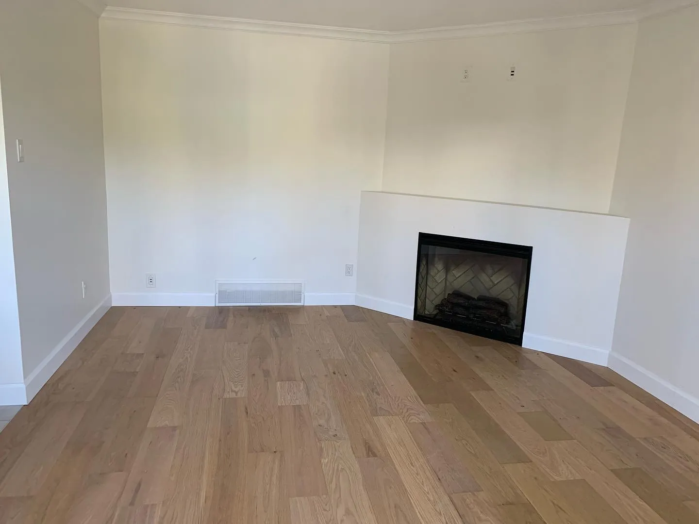 Living room with new wide-plank hardwood flooring and fresh paint